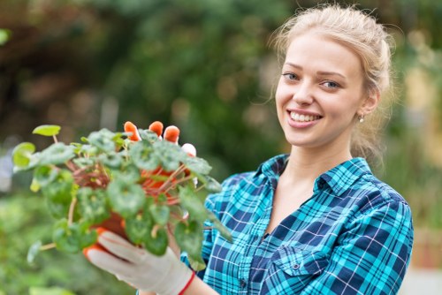 Community gardener tending plants in a Yiewsley garden